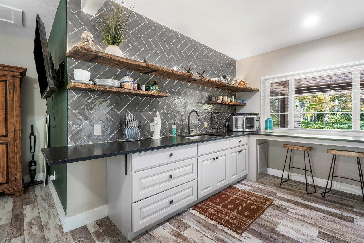 706 Sunset Road, Unit C West Palm Beach, FL 33401 - Photo 6 of 15 a kitchen with white cabinets and window