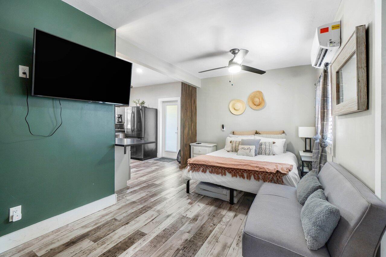 706 Sunset Road, Unit C West Palm Beach, FL 33401 - Photo 10 of 15 a spacious bedroom with a bed and a flat screen tv