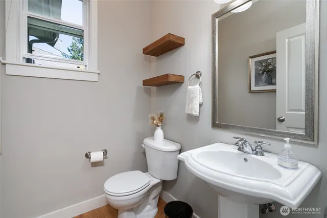 a bathroom with a sink a toilet and mirror