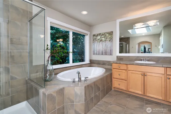 a spacious bathroom with a tub sink and mirror