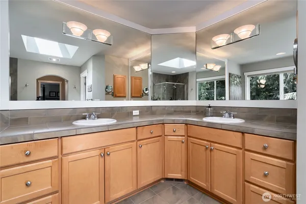 a bathroom with a granite countertop sink mirror and cabinets