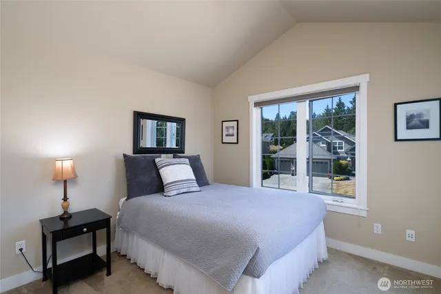 a bedroom with a bed and a lamp next to a window