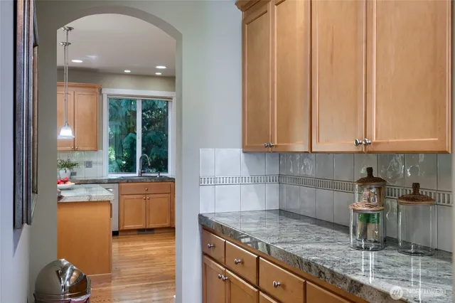 a kitchen with granite countertop a sink a stove and cabinets