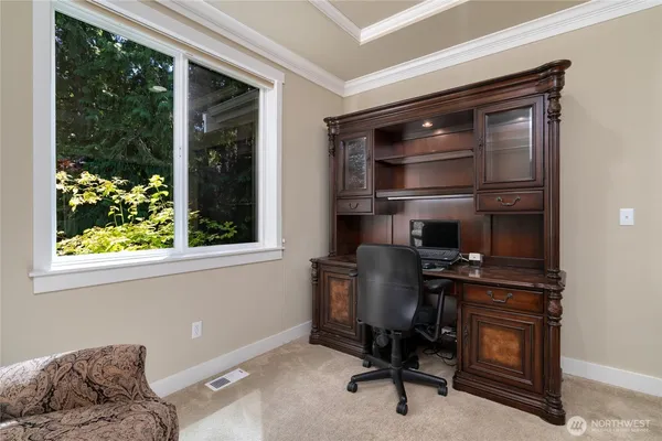 a view of a workspace with furniture and a window
