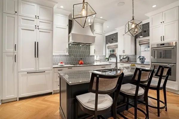 a kitchen with stainless steel appliances granite countertop a table chairs stove and refrigerator