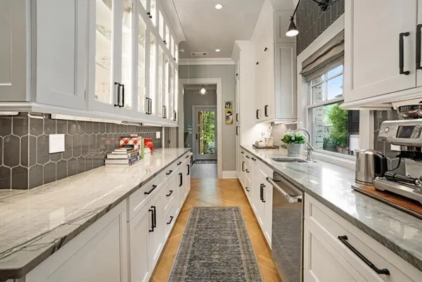 a large kitchen with stainless steel appliances granite countertop lots of counter top space and wooden floor