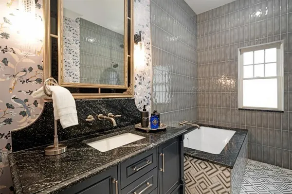 a bathroom with a granite countertop bathtub and shower