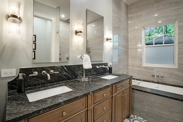 a bathroom with a granite countertop sink a toilet a mirror and shower