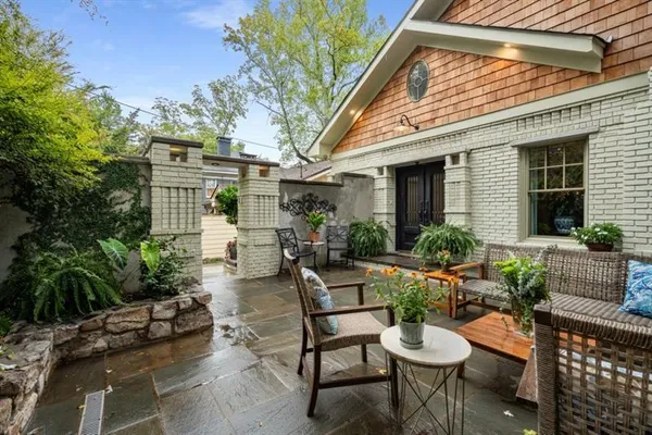 a view of a patio with couches table and chairs and potted plants