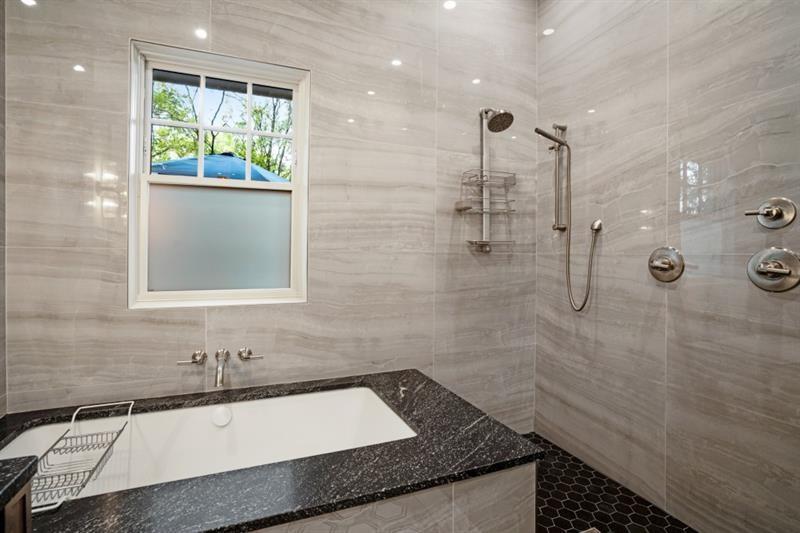 407 8th Street Northeast Atlanta, GA 30309 - Photo 31 of 34 a bathroom with a granite countertop sink a toilet a mirror and shower