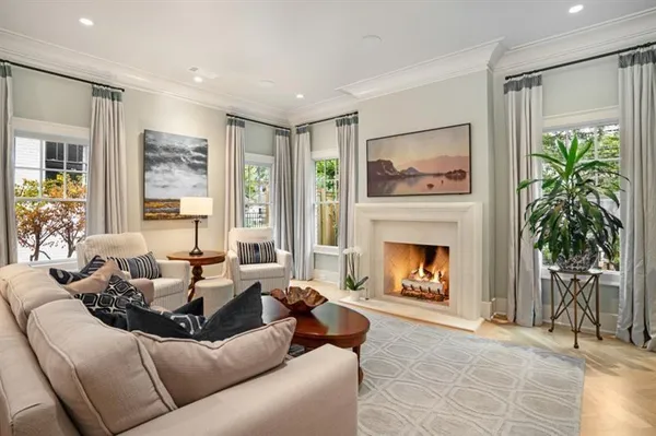 a living room with furniture a fireplace and a large window