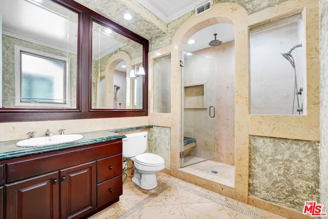 a bathroom with a granite countertop sink toilet and shower