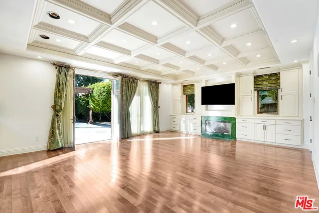 a view of empty room with wooden floor and fireplace