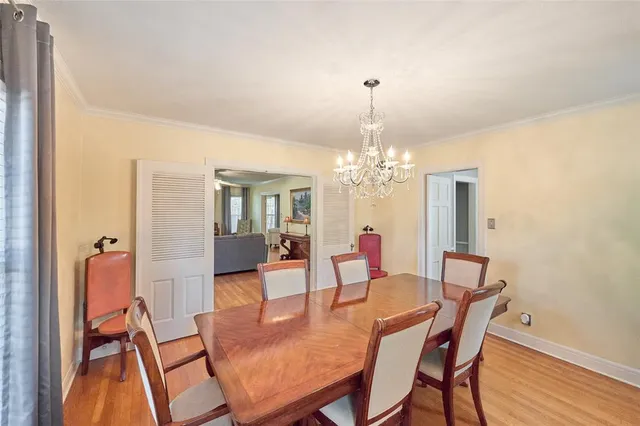 a view of a dining room with furniture a chandelier and wooden floor