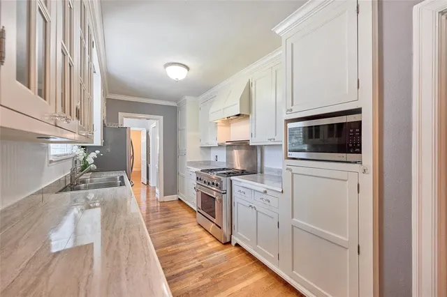 a kitchen with white cabinets and stainless steel appliances