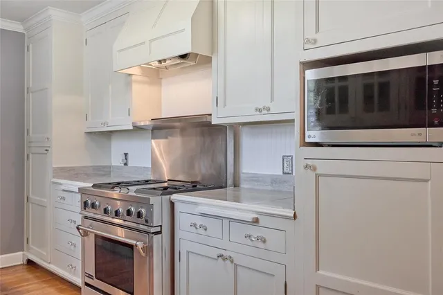a kitchen with granite countertop white cabinets and stainless steel appliances