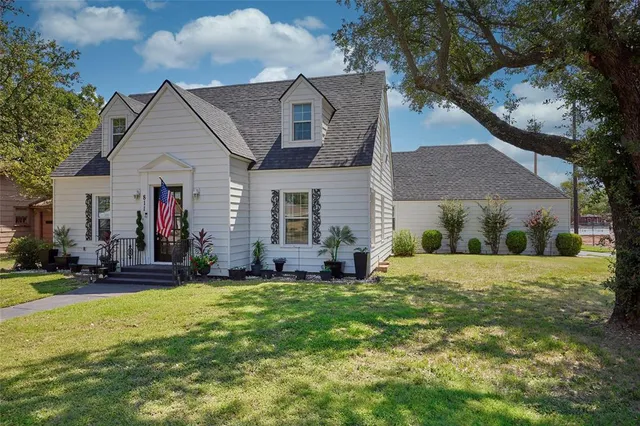 a front view of a house with a yard and trees