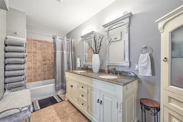 a bathroom with a double vanity sink a mirror and a bathtub