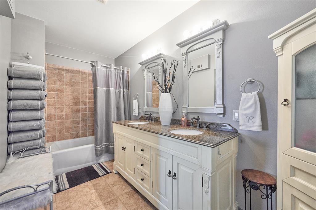 811 West Main Street Olney, TX 76374 - Photo 25 of 40 a bathroom with a double vanity sink a mirror and a bathtub