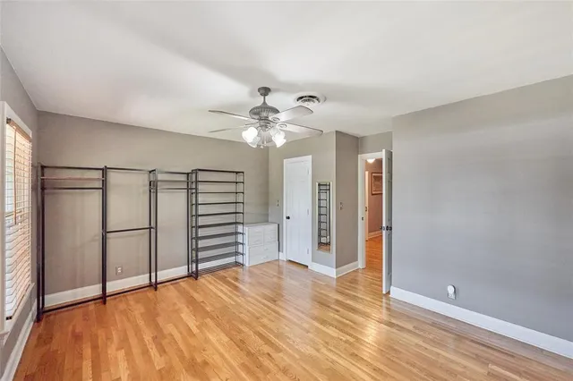 a view of a room with wooden floor and ceiling fan