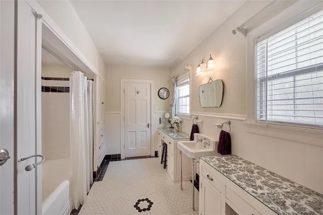 a spacious bathroom with a granite countertop sink mirror and a bathtub