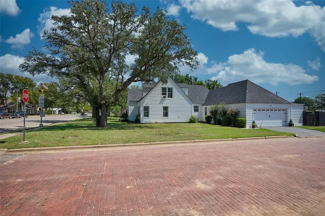 a house view with a backyard space and large trees
