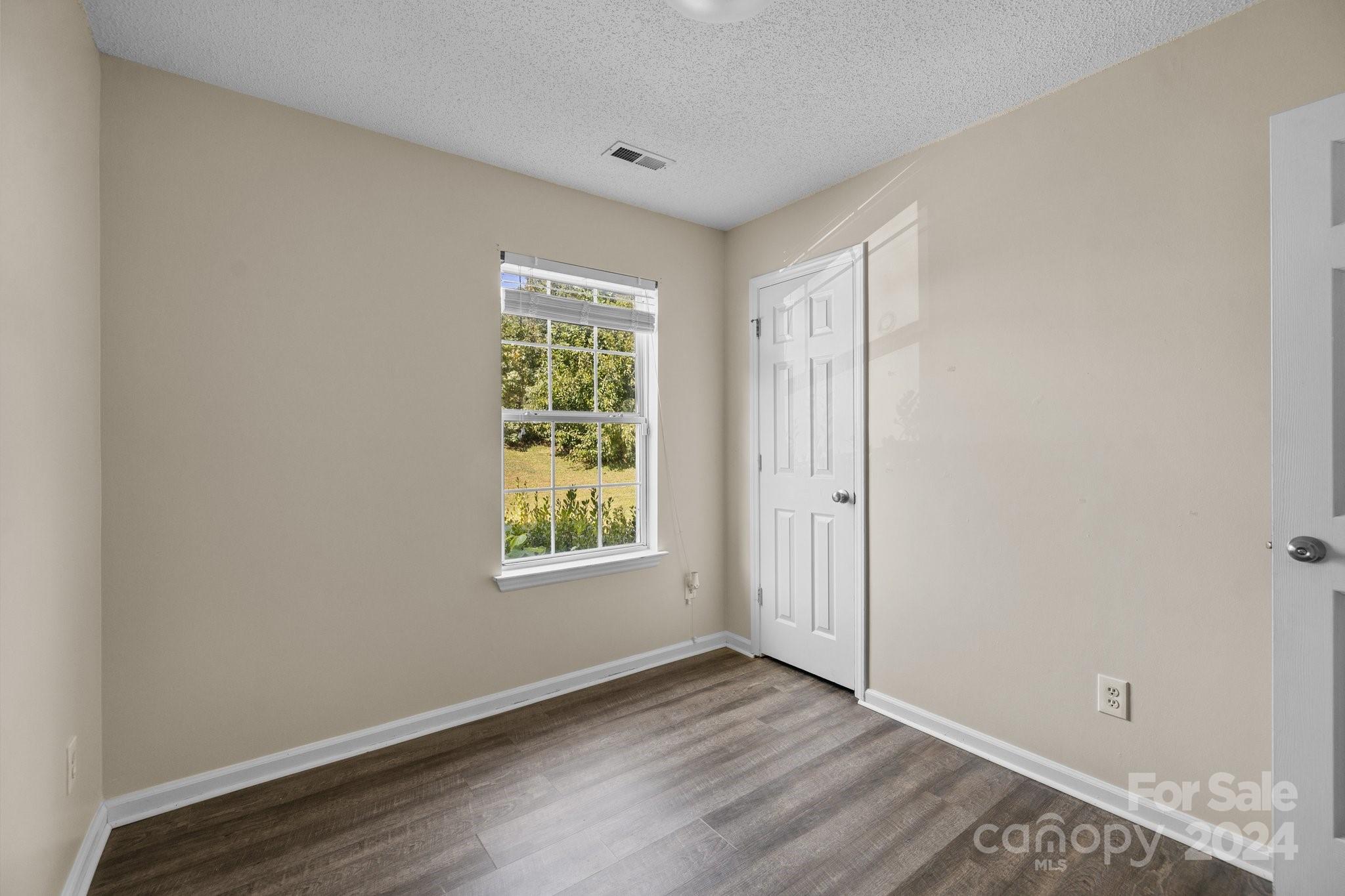 4340 Frank Vance Road Charlotte, NC 28216 - Photo 9 of 31 an empty room with wooden floor and windows