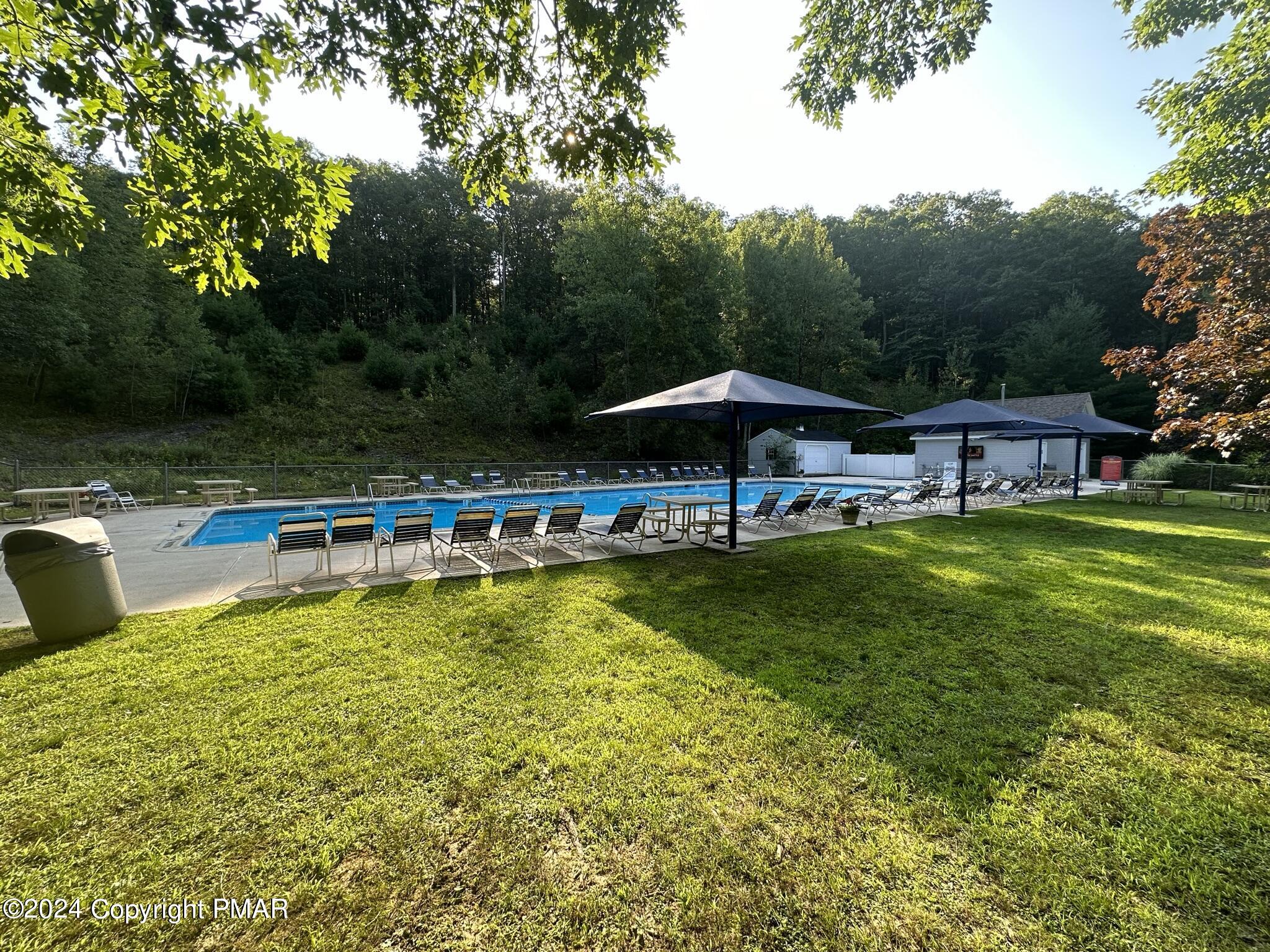 Lot 139 Berkshire Court Bushkill, PA 18324 - Photo 33 of 52 a view of a swimming pool with table and chairs under an umbrella