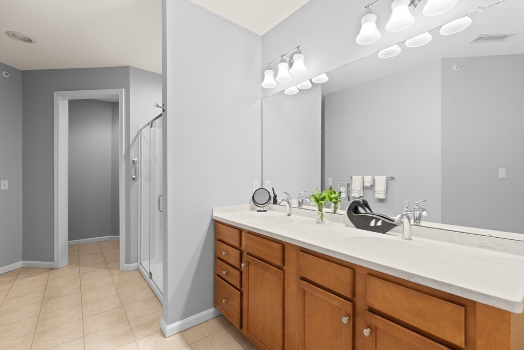 418 John Mahar Highway, Unit 408 Braintree, MA 02184 - Photo 15 of 35 a bathroom with a sink a potted plant and a mirror