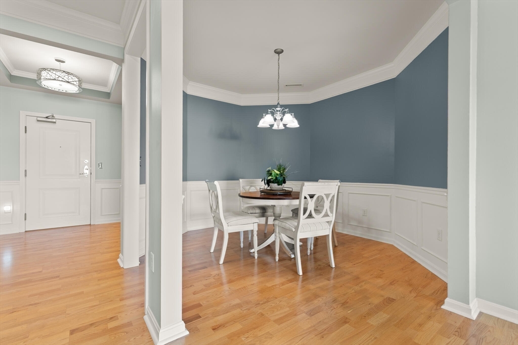 418 John Mahar Highway, Unit 408 Braintree, MA 02184 - Photo 8 of 35 a dining room with furniture a chandelier and wooden floor