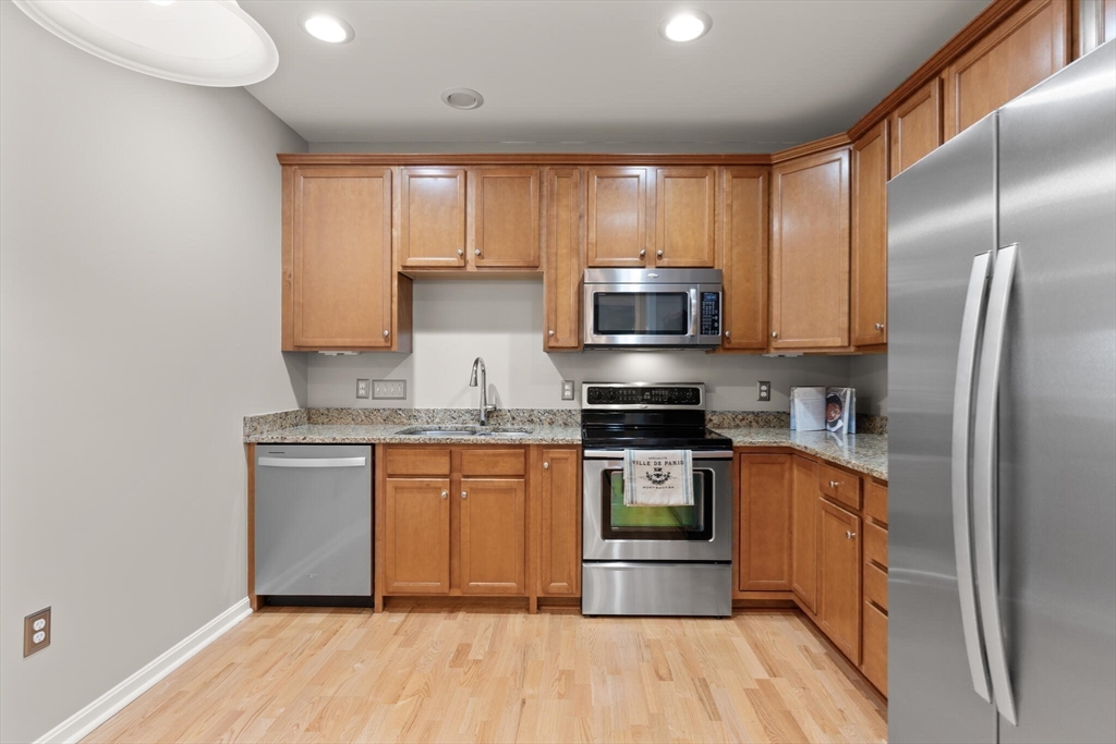 418 John Mahar Highway, Unit 408 Braintree, MA 02184 - Photo 10 of 35 a kitchen with stainless steel appliances granite countertop a stove a sink and a refrigerator