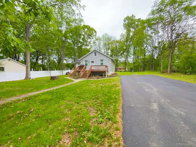 a front view of a house with garden and trees