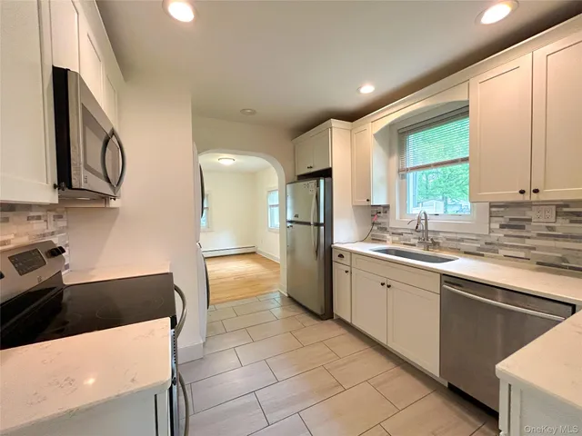 a large kitchen with stainless steel appliances a stove a sink dishwasher and a refrigerator