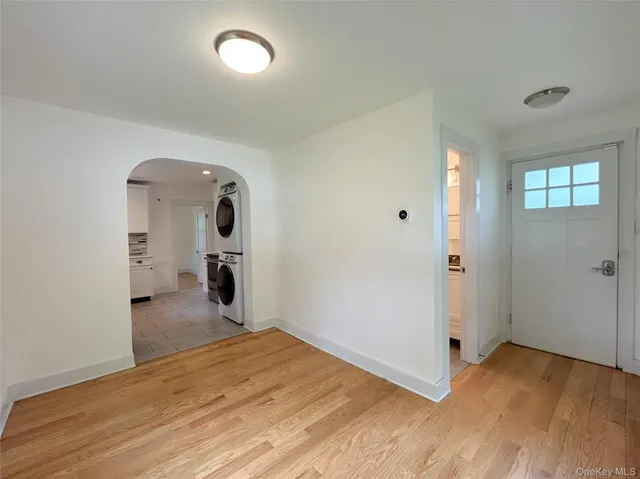 an empty room with wooden floor and mirror