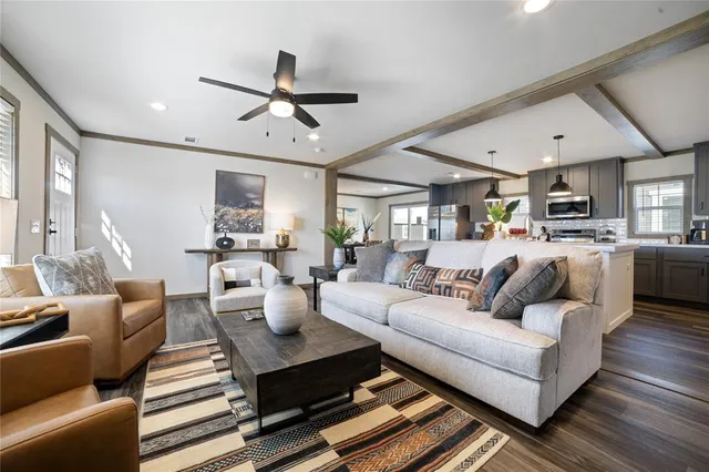 a living room with furniture kitchen view and a chandelier