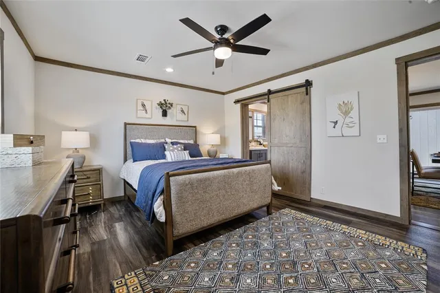 a bedroom with a bed and a dresser with wooden floor