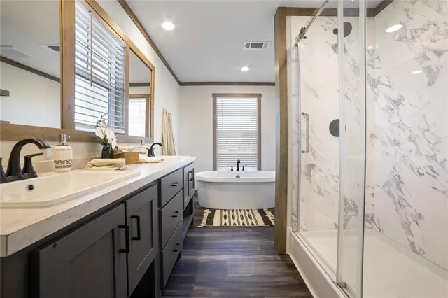 a bathroom with double vanity and a bathtub