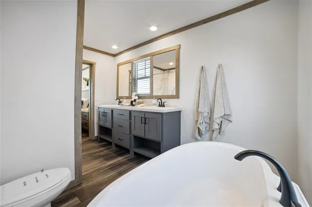 a bathroom with a double vanity sink a mirror and a bathtub