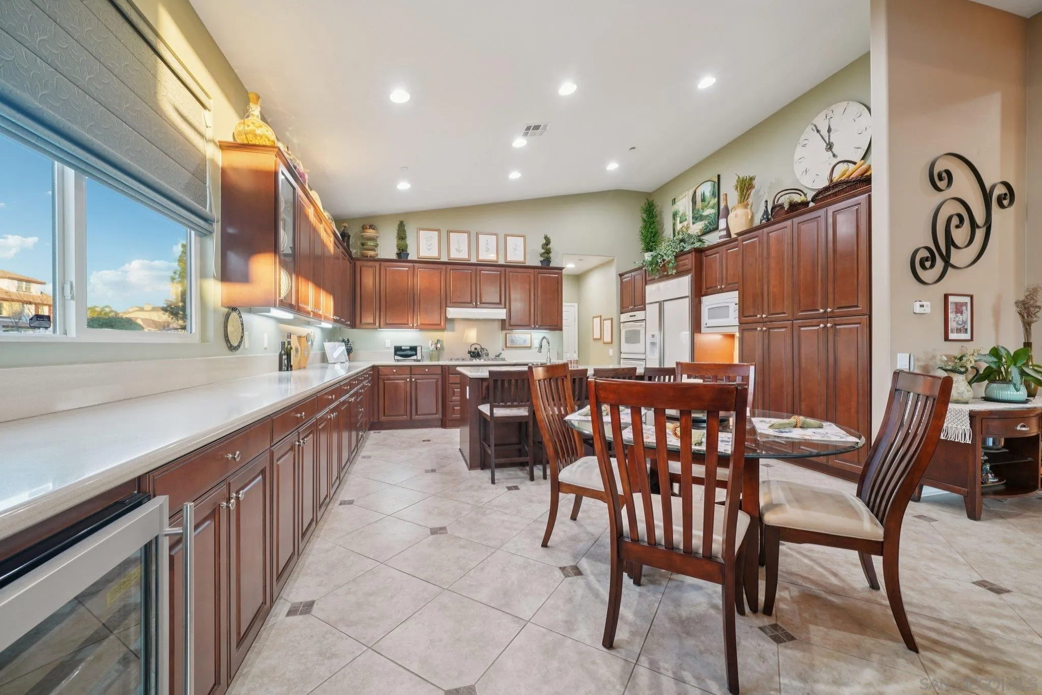 9471 Estrella Hills Street Riverside, CA 92508 - Photo 11 of 43 a kitchen with stainless steel appliances kitchen island granite countertop a table chairs and a refrigerator