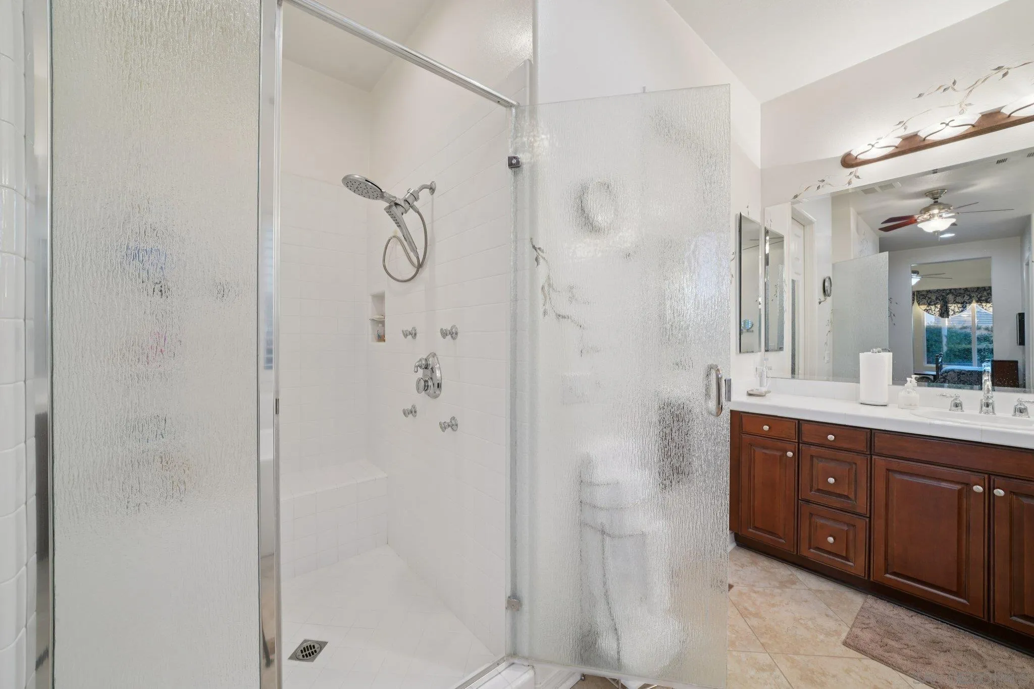 9471 Estrella Hills Street Riverside, CA 92508 - Photo 18 of 43 a bathroom with a granite countertop shower sink and mirror