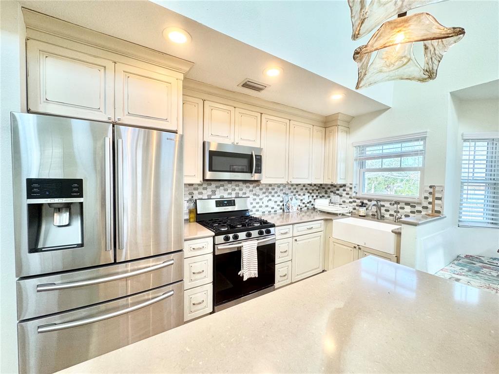 16204 3rd Street East Redington Beach, FL 33708 - Photo 12 of 58 a kitchen with stainless steel appliances a refrigerator stove and microwave
