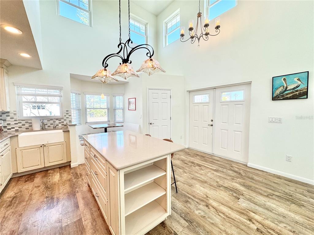 16204 3rd Street East Redington Beach, FL 33708 - Photo 13 of 58 a kitchen with a stove a sink a chandelier and living room view