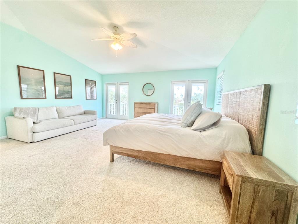 16204 3rd Street East Redington Beach, FL 33708 - Photo 27 of 58 a bedroom with a large bed and a chandelier