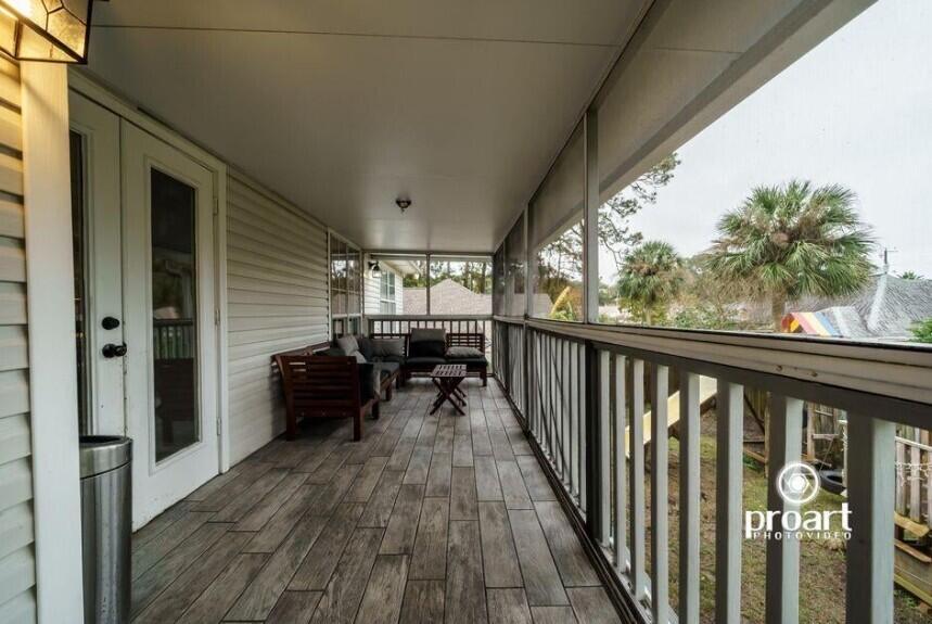 641 Bayshore Drive Destin, FL 32550 - Photo 23 of 34 a view of a balcony with chairs and wooden floor