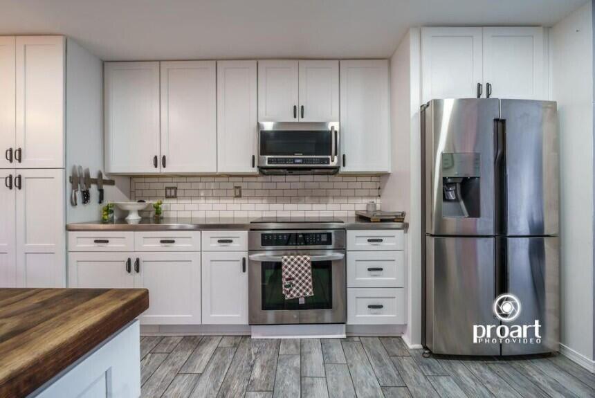 641 Bayshore Drive Destin, FL 32550 - Photo 33 of 34 a kitchen with granite countertop a refrigerator stove and white cabinets