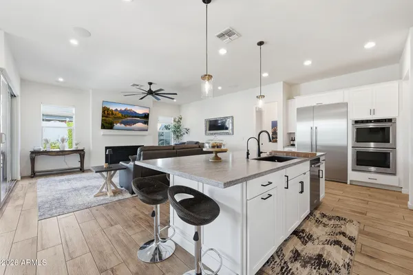 a large kitchen with granite countertop a stove a sink a window and chairs