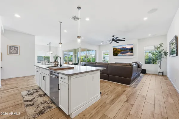 a kitchen with stainless steel appliances granite countertop a sink a stove and a wooden floors