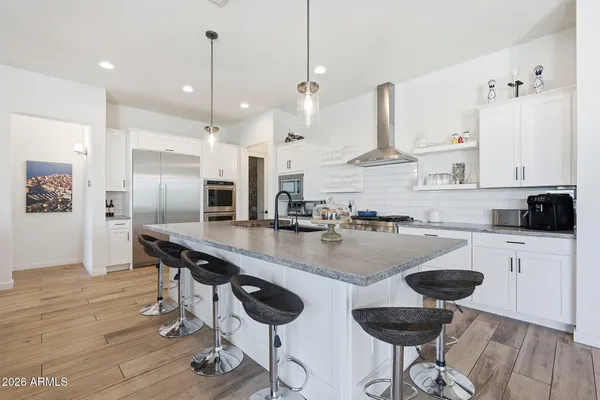 a kitchen with stainless steel appliances granite countertop a sink a stove and a refrigerator