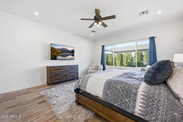 a bedroom with a bed a dresser and a window