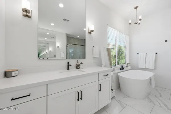 a bathroom with a double vanity sink mirror and bathtub